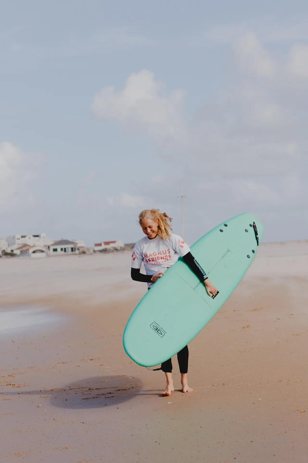 Kvinna med surfbräda påväg till vattnet