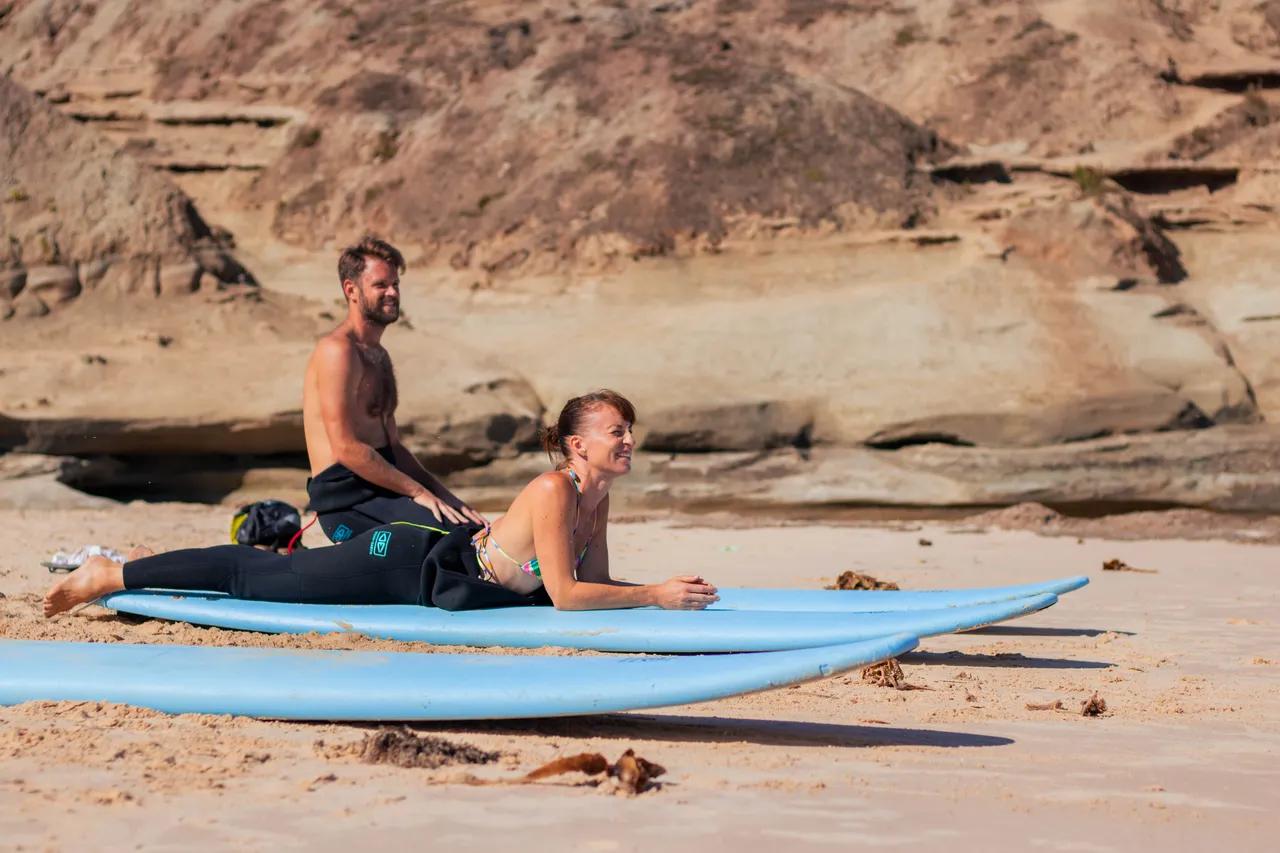 Surfare på stranden som övar pop-ups