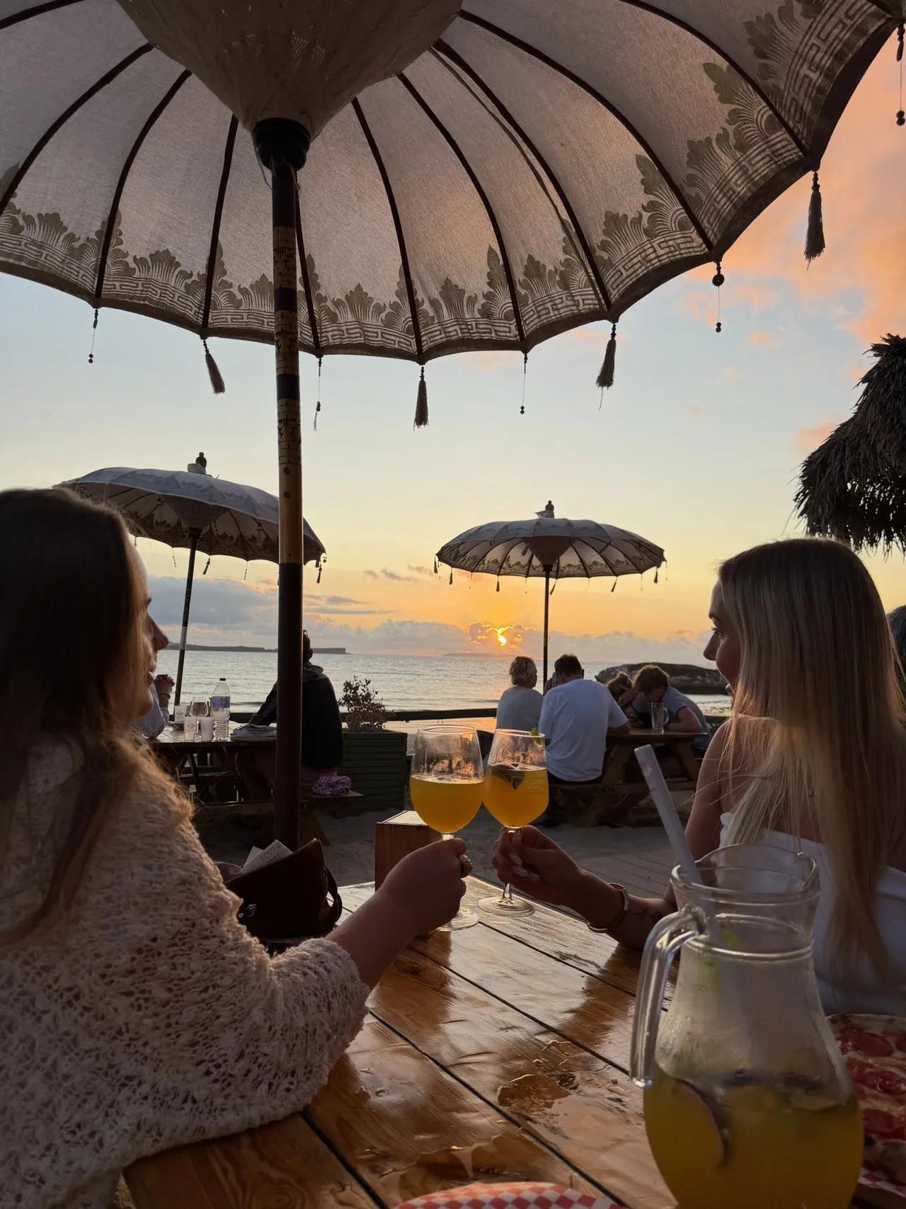 Drink i solnedgången med utsikt över havet.