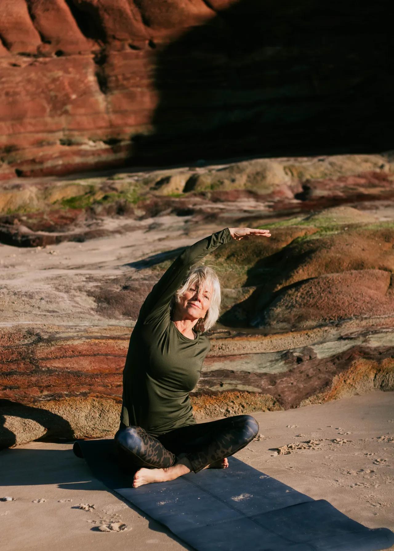 kvinna som gör yoga på klipporna