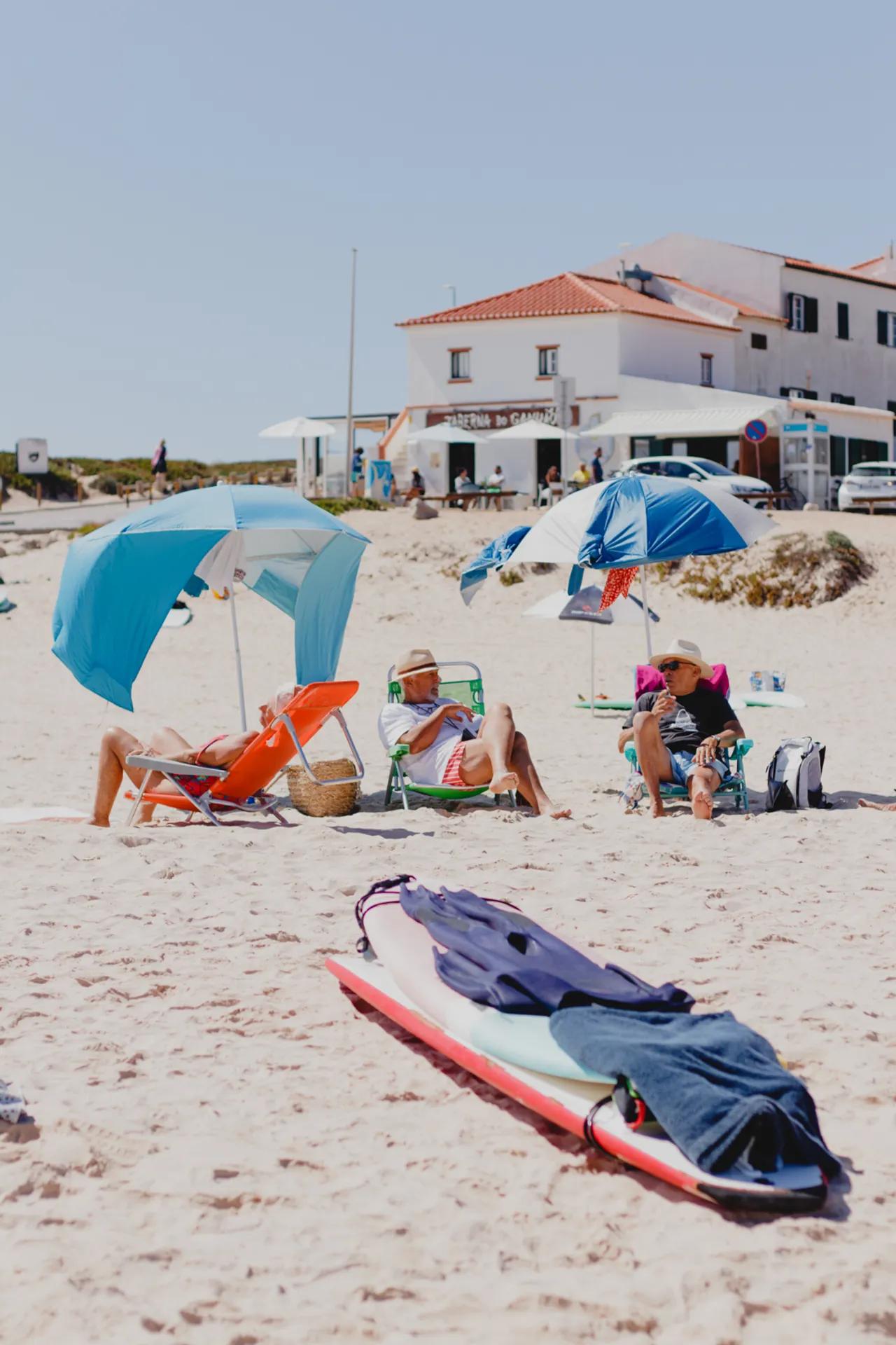 Personer som vilar under parasoll på stranden