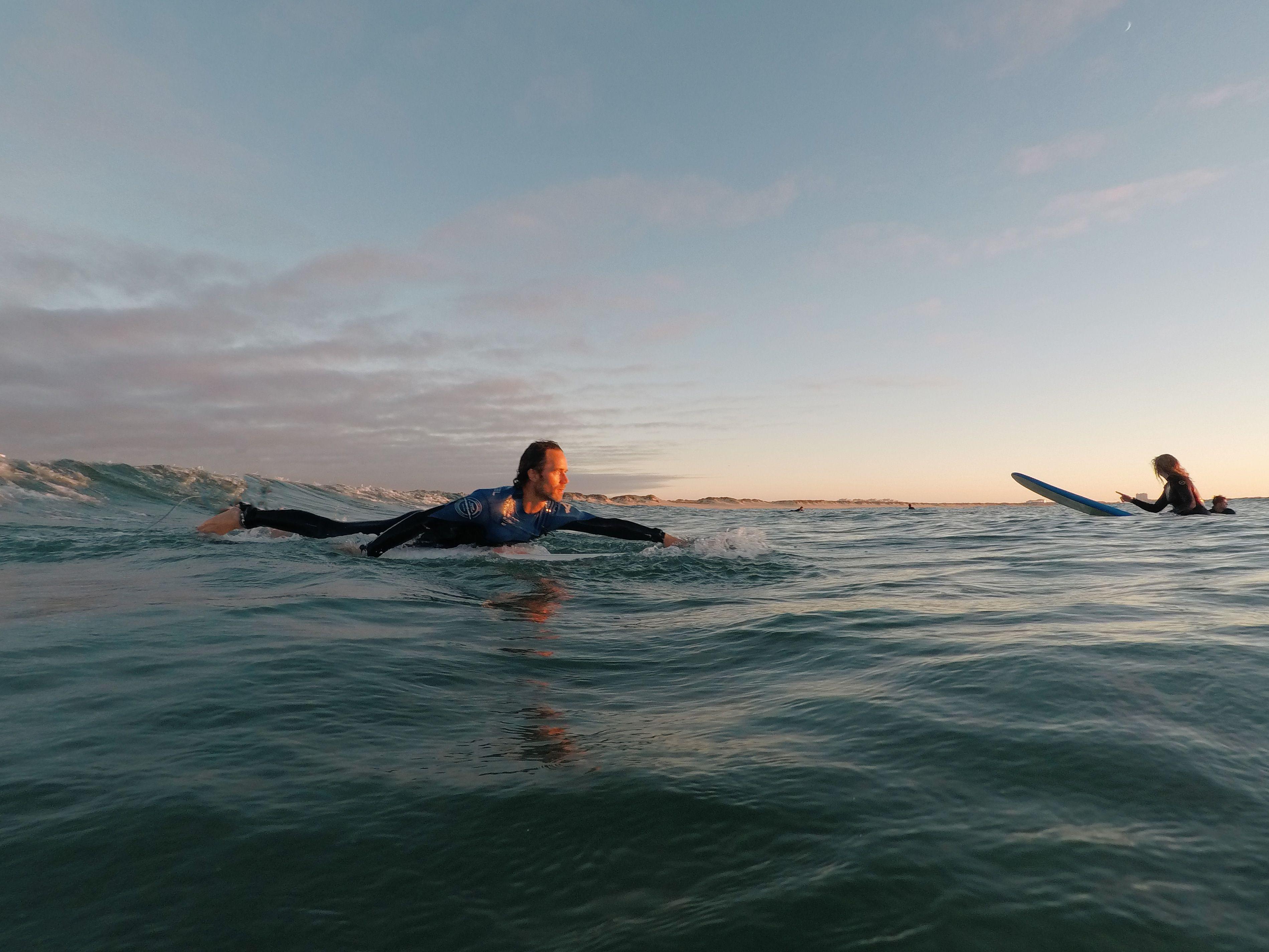 Person surfar i soluppgången