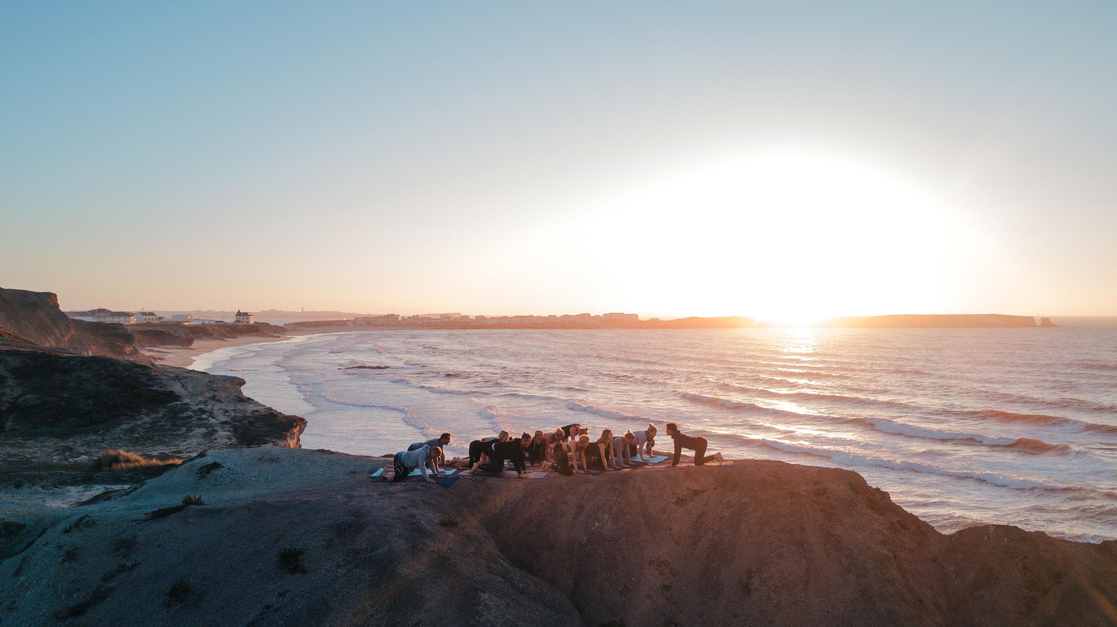 En grupp människor gör yoga i soluppgången