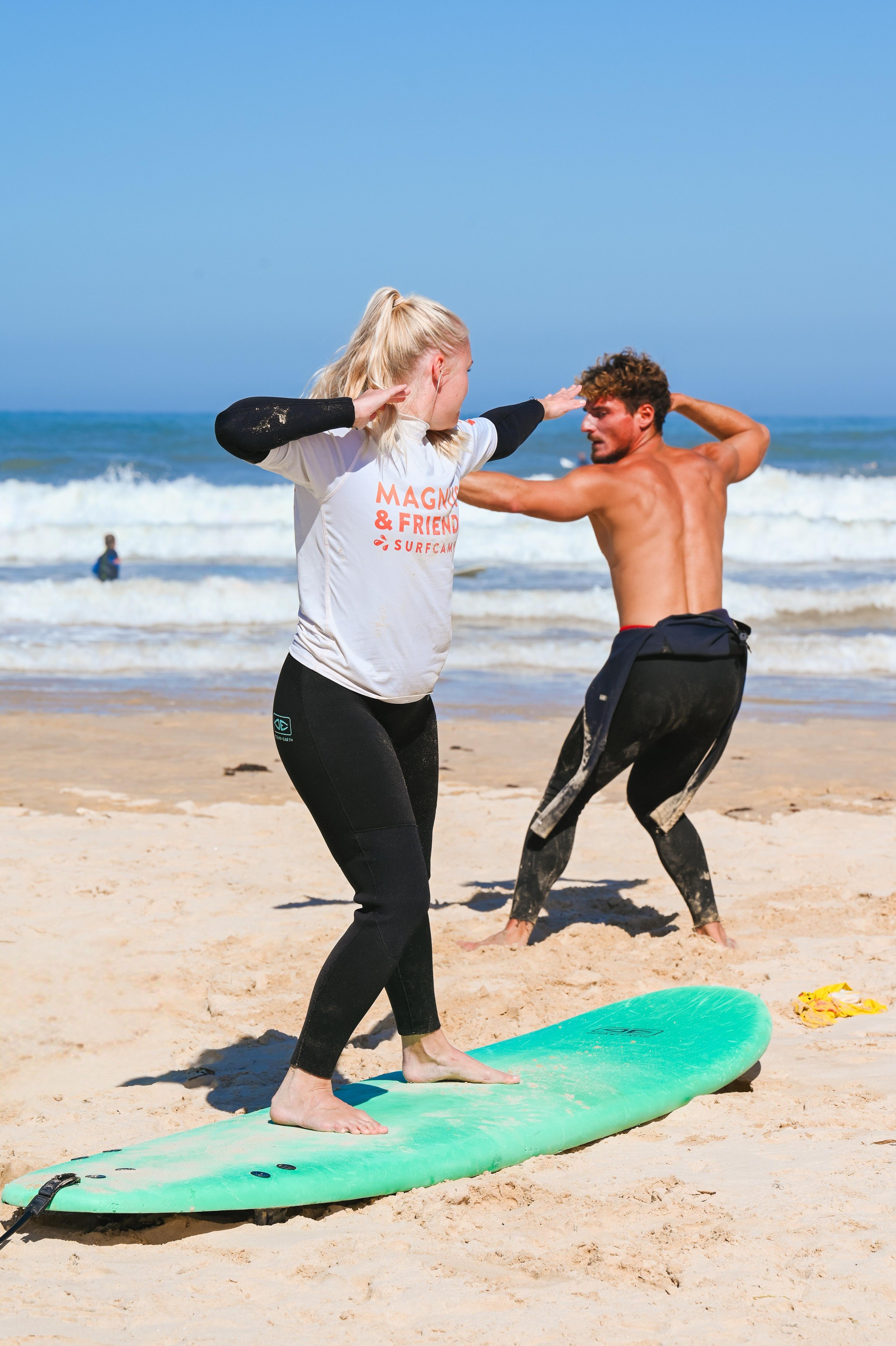 Instruktören Rodrigo ger instruktioner till en elev på stranden.