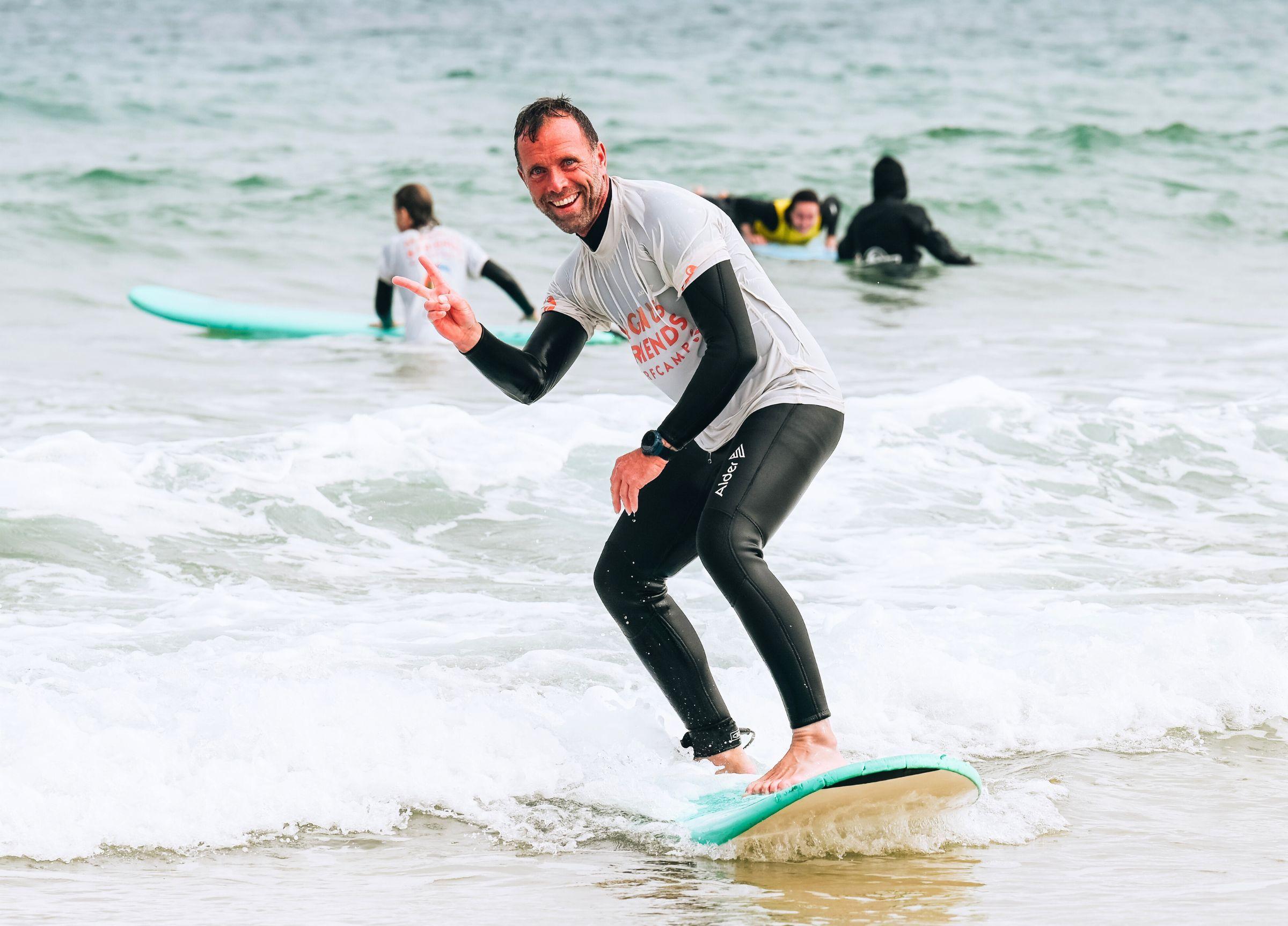 Glad man som surfar på vågor i Portugal hos Magnus & friends surfcamp