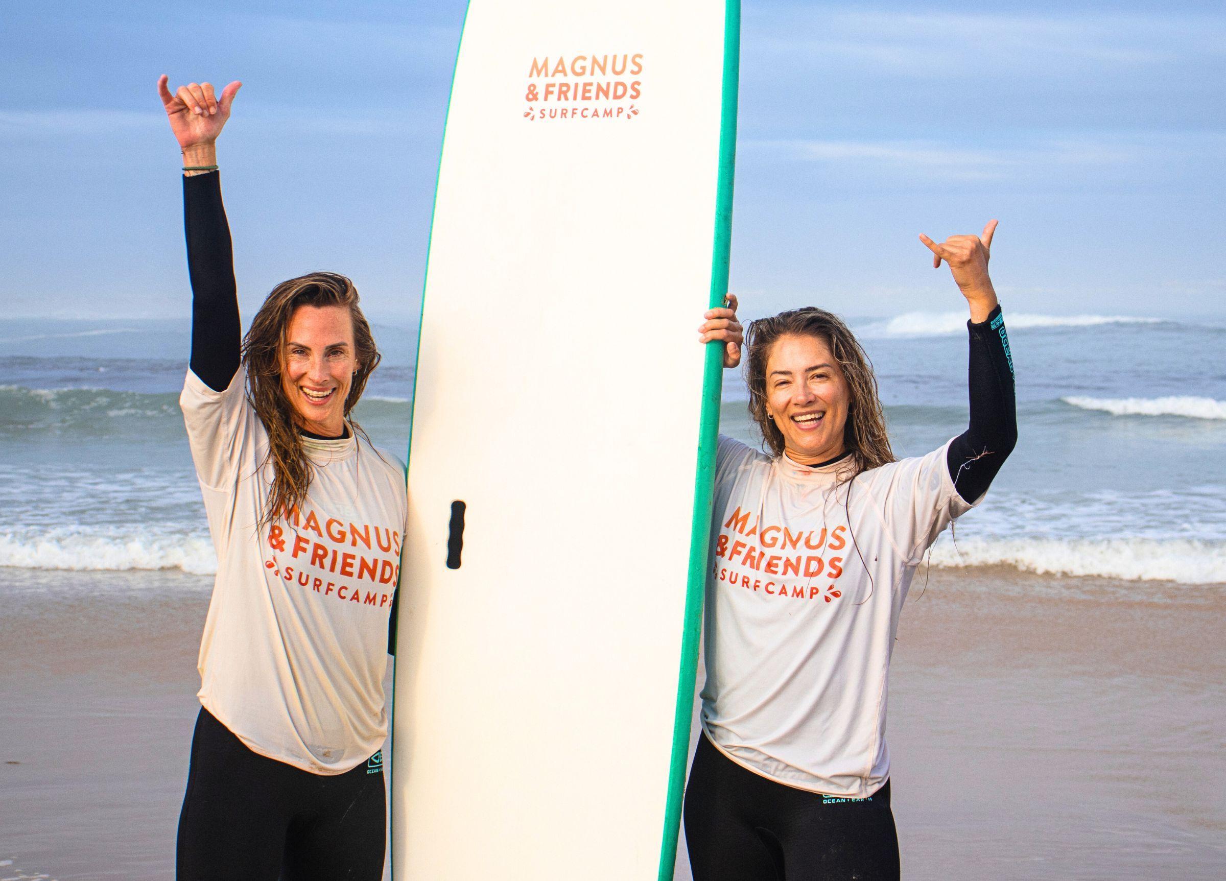 Andrea och Ida glada på stranden efter surflektion med Magnus & friends rashguards