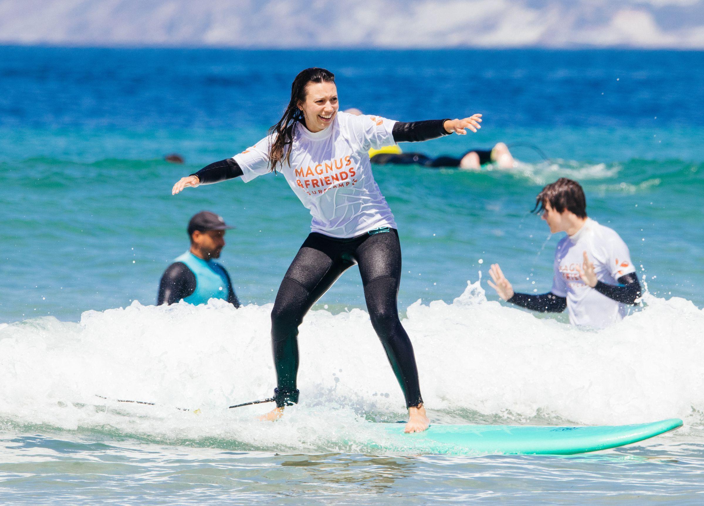 Glad tjej som surfar i Portugal.