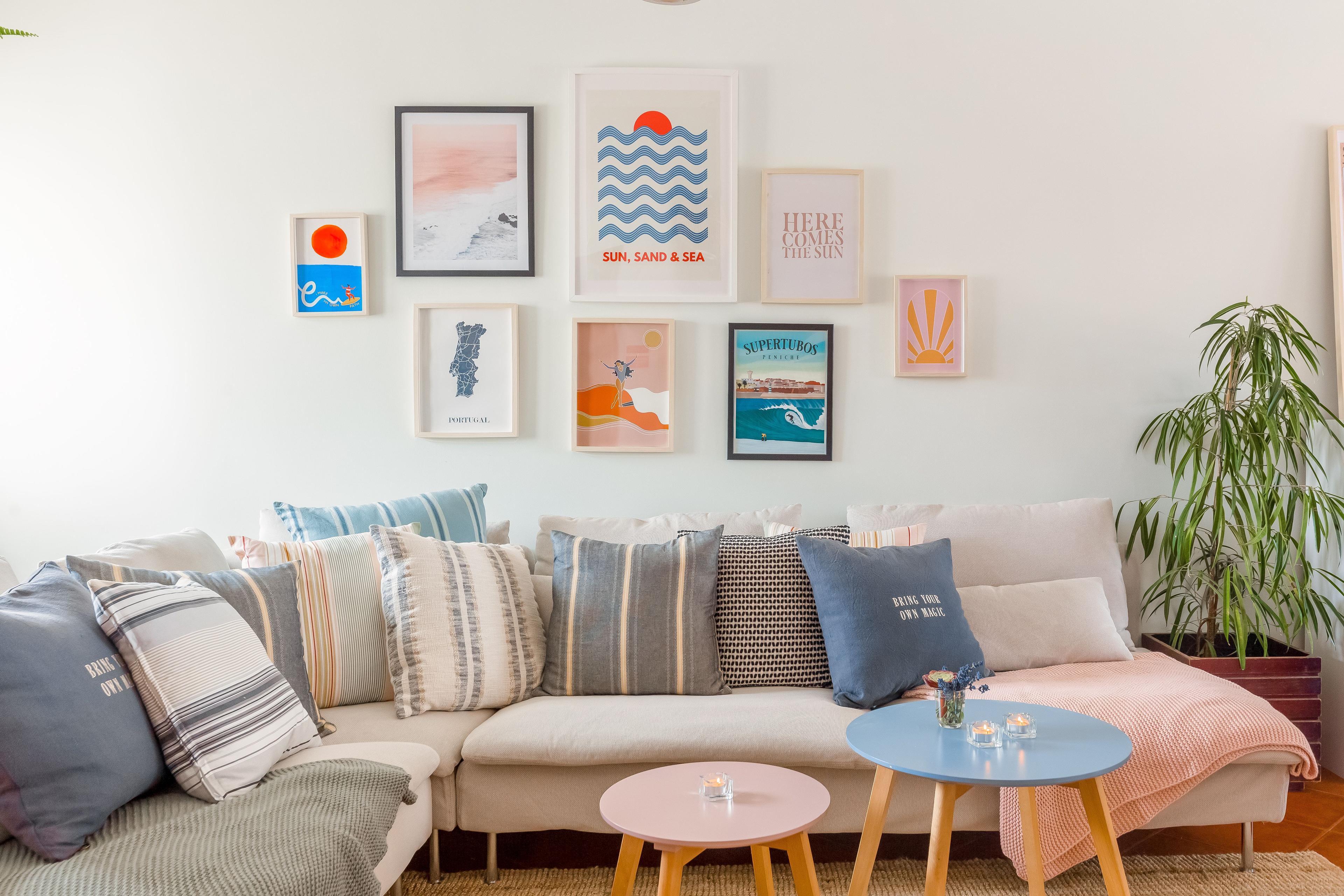 Mysigt vardagsrum med färgglada kuddar, ljusa möbler och väggdekorationer